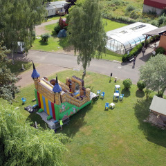 Vista aérea de un castillo hinchable y zonas verdes en Camping Seasonova Les Portes d'Alsace, Grand Est, Francia.