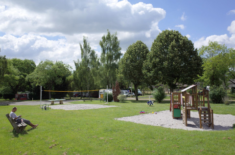 Parque infantil y pista de voleibol en Camping Seasonova Les Portes d'Alsace, Grand Est, Francia.