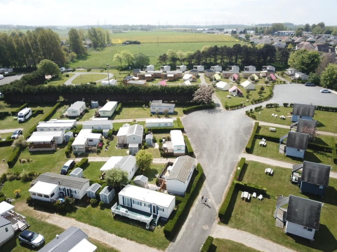 Vista aérea del Camping Seasonova Etennemare en Normandía, Francia, con casas móviles y áreas verdes.
