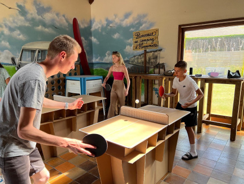 Zwei Personen spielen Tischtennis an einem Papp-Tisch im Camping Seasonova Etennemare in der Normandie, Frankreich.