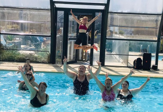 Groep mensen amuseren zich in het zwembad van Camping Seasonova Etennemare in Normandië, Frankrijk.
