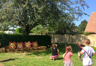 Bambini che praticano il tiro con l’arco all’aperto al Camping Seasonova Etennemare in Normandia, Francia.