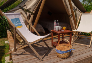Safari-Zelt Slow Life Stay auf dem Camping Seasonova Vittel mit Liegestühlen und Picknickkorb in Frankreich.
