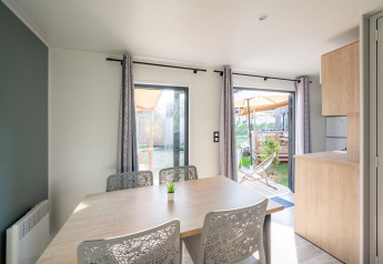 Lichte eetruimte in Cottage Prestige op Camping Seasonova Les Portes d'Alsace met zicht op het terras.