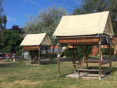 Bivouac safari tents at Camping Seasonova Les Portes d'Alsace with wooden frames and canvas roofs.