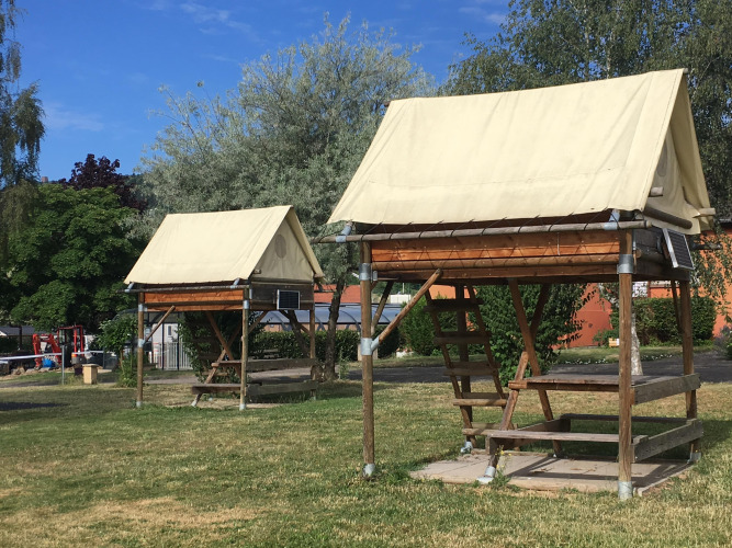 Tiendas tipo bivouac en Camping Seasonova Les Portes d'Alsace con estructura de madera y techos de lona.
