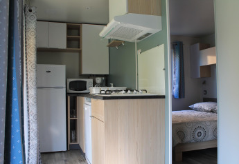 Angolo cottura e camera da letto moderni al Cottage Prestige del Camping Seasonova Etennemare in Francia.