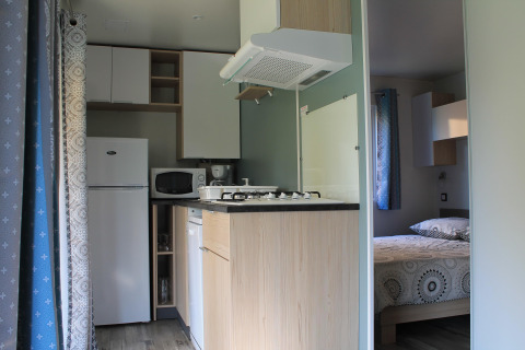 Kompakte Küchen- und Schlafbereiche im Cottage Prestige bei Camping Seasonova Etennemare, Frankreich.