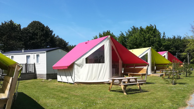 Coloridas tiendas safari y casas móviles en Camping Seasonova Etennemare, Francia, bajo un cielo soleado.