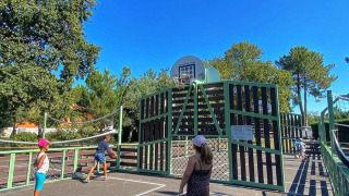 Niños jugando en una cancha al aire libre en Village Seasonova Bassin d'Arcachon, parque vacacional en Francia.