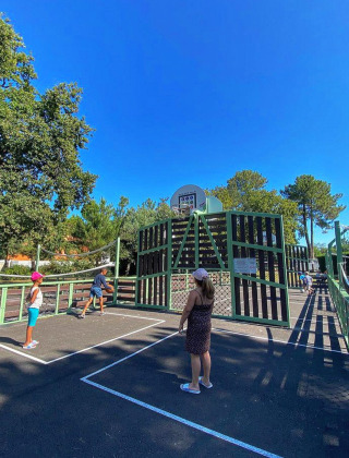 Niños jugando en una cancha al aire libre en Village Seasonova Bassin d'Arcachon, parque vacacional en Francia.