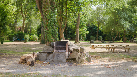 Barbacoa al aire libre y mesas de picnic en el Camping Seasonova du Chêne, Pays de la Loire, Francia.