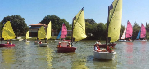 Niños navegan en pequeños barcos coloridos en un lago cerca de Saint Julien de Concelles, Pays de la Loire, Francia.