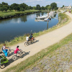 Radweg am Fluss bei Camping Seasonova du Chêne in Pays de la Loire, Frankreich, mit Familien beim Radfahren.