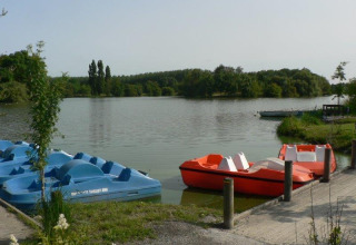 Pedalbåde ved søbredden på Camping Seasonova du Chêne, et feriested i Pays de la Loire, Frankrig.