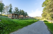 Træhytter ved Domaine Seasonova Saâne et Mer feriested omgivet af grønne marker i Normandiet, Frankrig