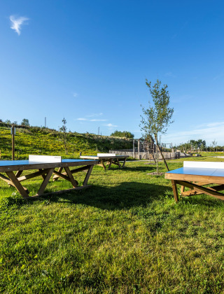 Mesas de ping-pong al aire libre en el césped del parque vacacional Domaine Seasonova Saâne et Mer en Normandía.