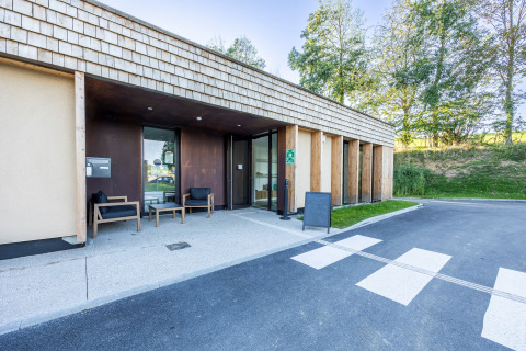 Ingang van Domaine Seasonova Saâne et Mer vakantiepark in Normandië, Frankrijk met moderne houten gevel.