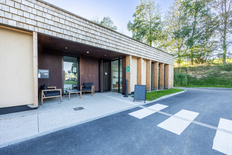 Eingang zum Domaine Seasonova Saâne et Mer Ferienpark in der Normandie, Frankreich mit moderner Holzfassade.