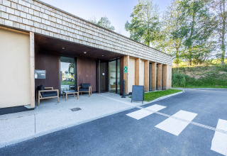 Ingresso del parco vacanze Domaine Seasonova Saâne et Mer in Normandia, Francia, con facciata moderna in legno.