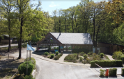Ingresso del Camping Seasonova La Forêt nei Pays de la Loire, Francia, circondato da alberi e natura.