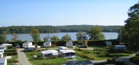 Vista panorámica de Camping Seasonova La Forêt con caravanas junto a un lago en Pays de la Loire, Francia.