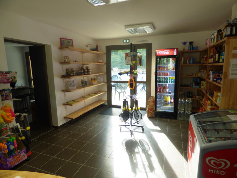 Interior de tienda en Camping Seasonova La Forêt en Pays de la Loire, Francia, con estantes y nevera.