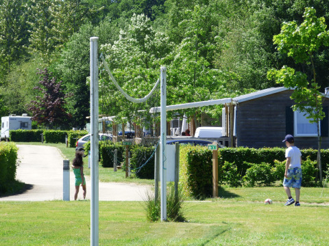 Dos niños juegan al aire libre cerca de casas móviles en Camping Seasonova La Forêt, Pays de la Loire, Francia.