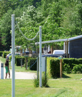 Dos niños juegan al aire libre cerca de casas móviles en Camping Seasonova La Forêt, Pays de la Loire, Francia.