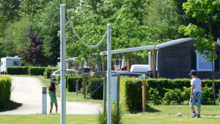 Dos niños juegan al aire libre cerca de casas móviles en Camping Seasonova La Forêt, Pays de la Loire, Francia.