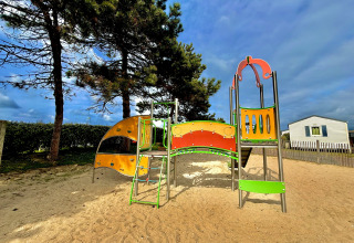 Speeltuin met kleurrijke klimstructuur op Camping Seasonova Le Point du Jour, vakantiepark in Normandië.