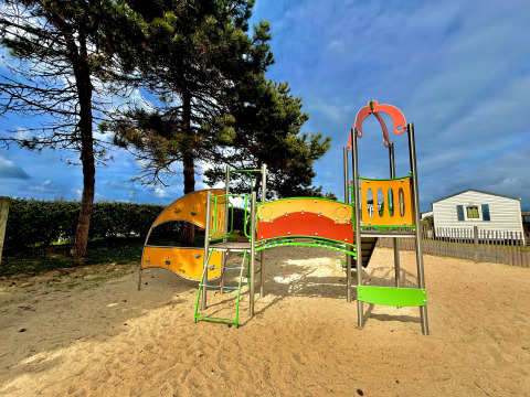 Spielplatz mit buntem Klettergerüst im Camping Seasonova Le Point du Jour, Ferienpark in der Normandie.