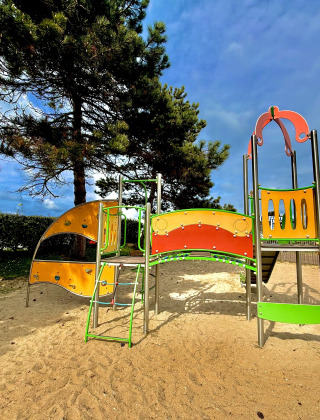 Parque infantil con estructura colorida en Camping Seasonova Le Point du Jour, parque vacacional en Normandía.