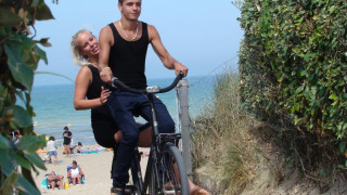 Un jeune couple fait du vélo près de la plage au Camping Seasonova Le Point du Jour en Normandie, France.
