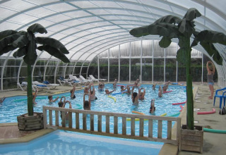 Indoor swimming pool and aqua aerobics class at Camping Seasonova Le Point du Jour in Normandy, France.