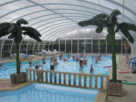 Piscina cubierta con clase de aeróbic acuático en Camping Seasonova Le Point du Jour en Normandía, Francia.