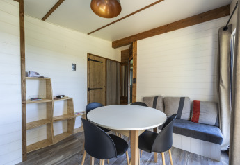 Sala moderna en Cottage Premium en Domaine Seasonova Saâne et Mer, con mesa de comedor y sofá elegante.