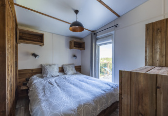 Chambre du Cottage Premium au Domaine Seasonova Saâne et Mer en France, avec déco bois et balcon.