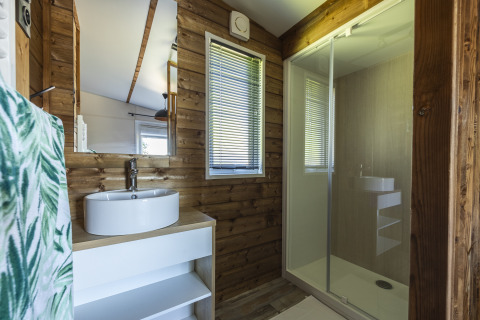 Baño moderno de cabaña de madera en Domaine Seasonova Saâne et Mer con lavabo redondo y ducha amplia.