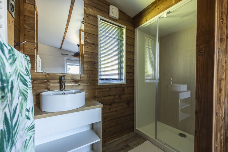 Baño moderno de cabaña de madera en Domaine Seasonova Saâne et Mer con lavabo redondo y ducha amplia.