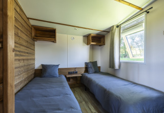 Habitación con dos camas individuales, detalles en madera y ventana en Cottage Premium, Domaine Seasonova Saâne et Mer, Francia.