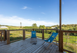 Houten terras met twee blauwe ligstoelen bij Prestige Cottage in Domaine Seasonova Saâne et Mer, Frankrijk.