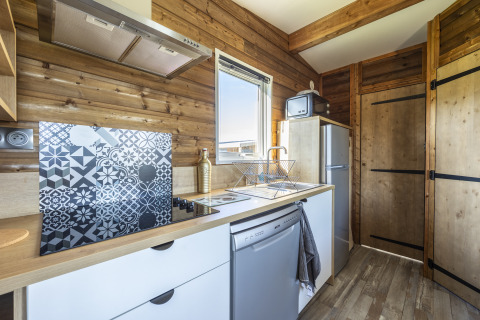 Moderne køkken i Prestige Cottage på Domaine Seasonova Saâne et Mer, Frankrig, med trævægge og vindue.