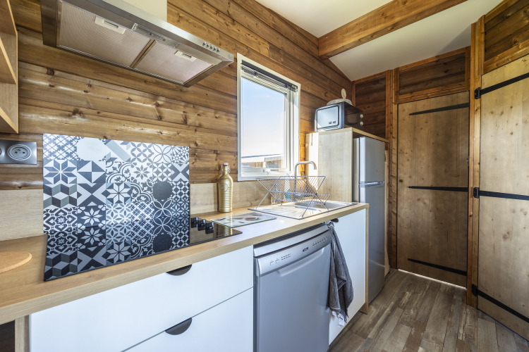 Cocina moderna en Prestige Cottage en Domaine Seasonova Saâne et Mer, Francia, con paredes de madera.