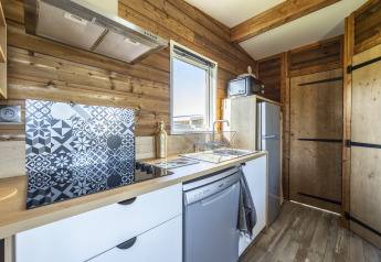 Cocina moderna en Prestige Cottage en Domaine Seasonova Saâne et Mer, Francia, con paredes de madera.