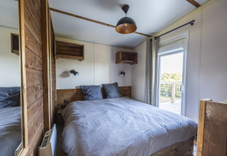 Dormitorio en Prestige Cottage de Domaine Seasonova Saâne et Mer con cama doble y gran puerta al balcón.