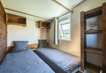 Kamer met twee eenpersoonsbedden, houten rekken en raam in Prestige Cottage, Domaine Seasonova Saâne et Mer, Frankrijk.