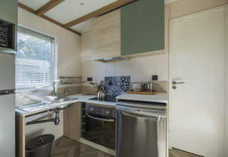 Cocina accesible en Cottage PMR con electrodomésticos modernos en Domaine Seasonova Saâne et Mer, Francia.