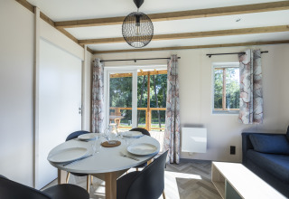Modern dining area in Cottage PMR at Domaine Seasonova Saâne et Mer with view to terrace and greenery.
