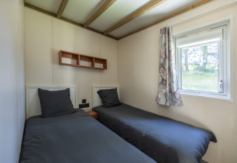 Due letti singoli con biancheria scura in una stanza accessibile al Cottage PMR, Domaine Seasonova Saâne et Mer in Francia.